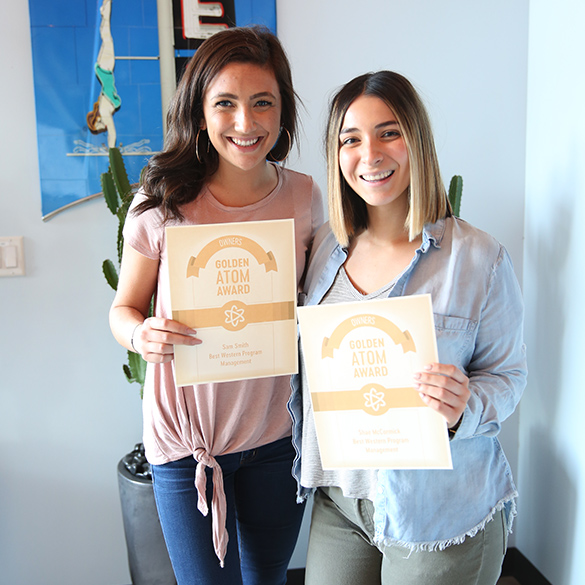 Two women holding awards